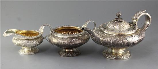 A George IV three piece embossed silver tea service of compressed melon form, William Hewitt? London 1824, gross 48 oz.